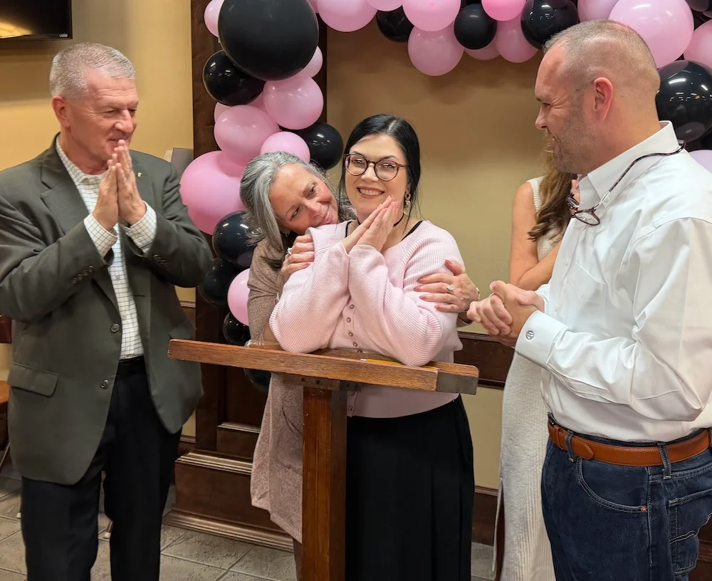 A Hope for Women graduate celebrates with family members.