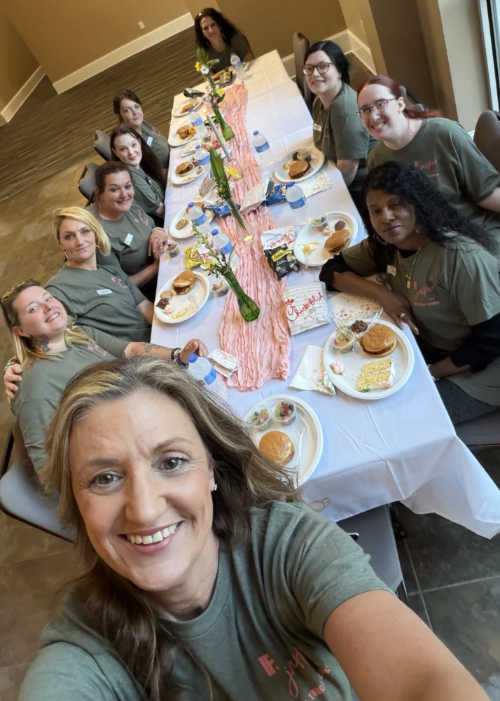 Women gather around a table for a shared meal.